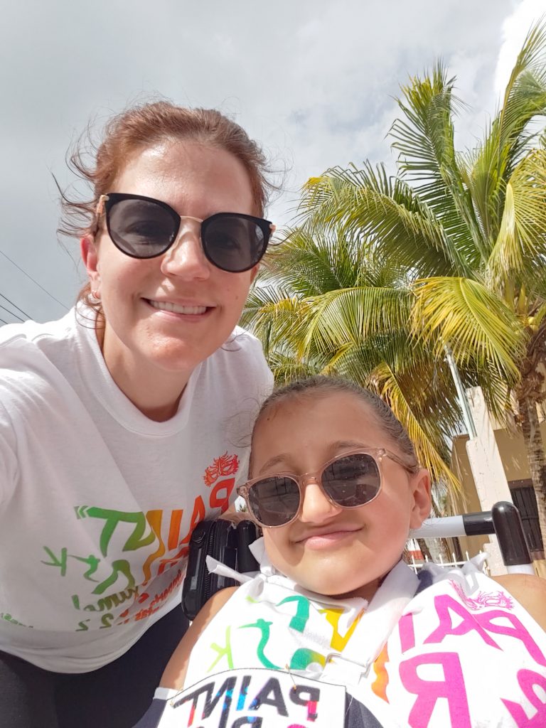 Anna and her mom take a picture before the race. Their fair skin is clean, along with their Paint and Run shirts.
