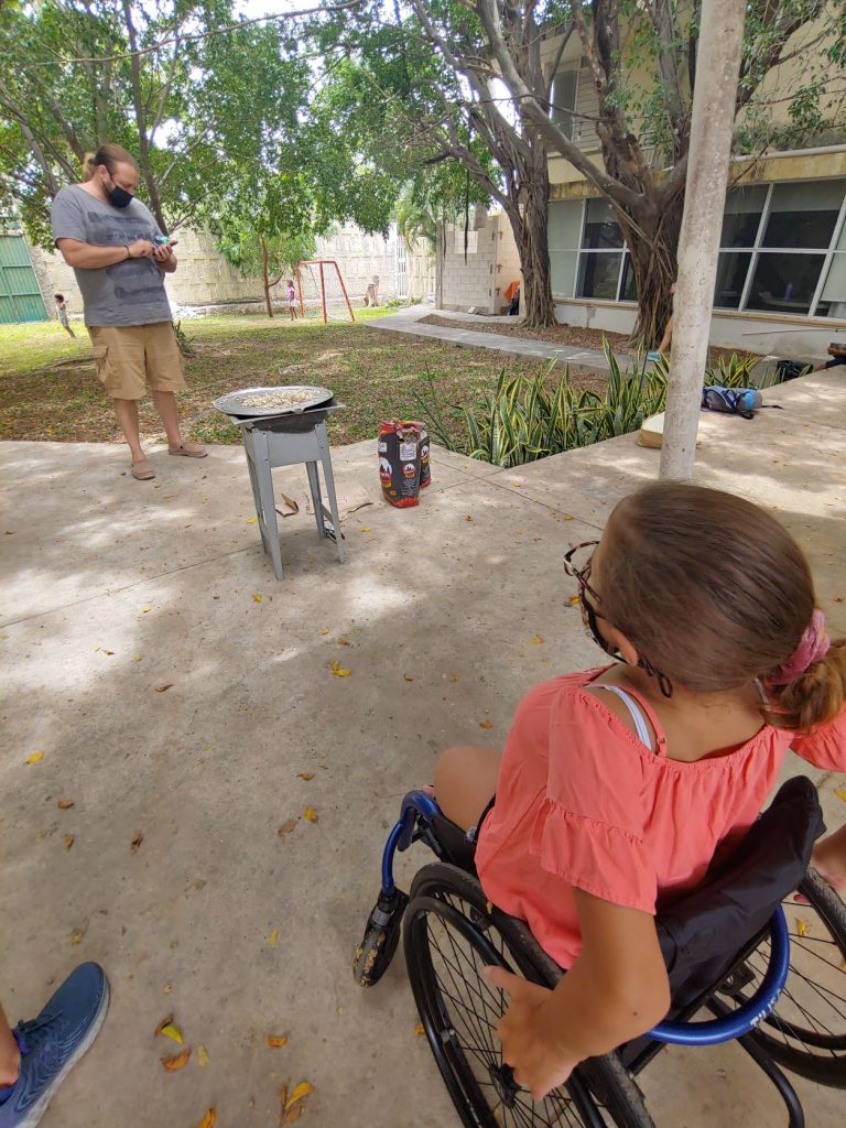 Girl in wheelchair learning to make tortillas during accessible Spanish lesson in Merida, Mexico.