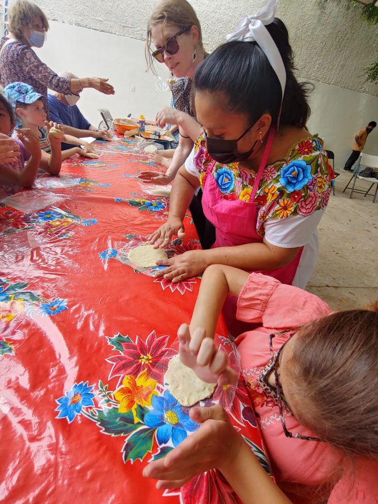 Girl in wheelchair learning to make tortillas during accessible Spanish lesson in Merida, Mexico.