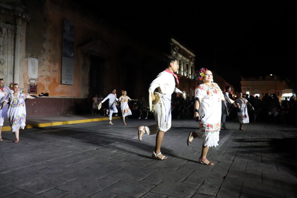 Four pairs of Latino dancers take a step along with the rhythm of the traditional music. Each pair consists of a man and a woman.