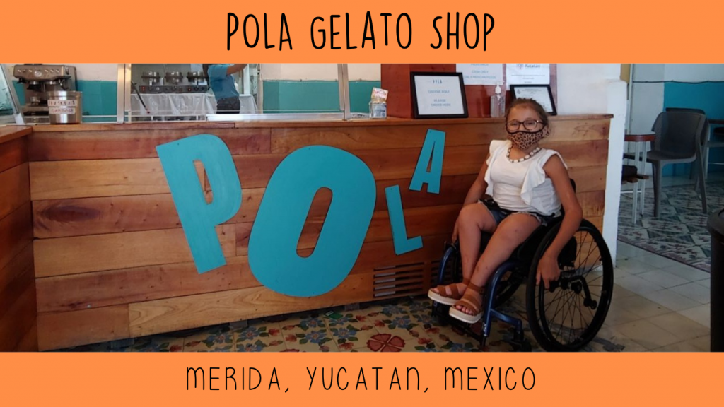 Teen in wheelchair poses at Pola gelato shop in Merida, Mexico to give accessibility review.